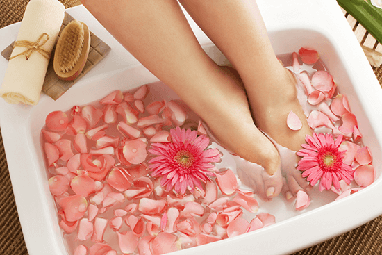 feet in a soaking in tub with flowers