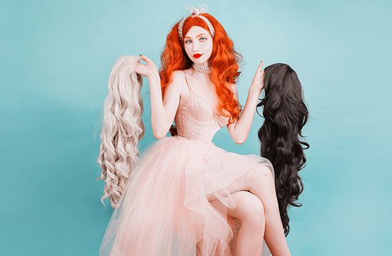 lady holding different colored wigs