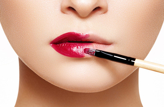 applying lipstick using lip brush