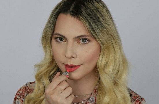 Transgender woman putting on lipstick